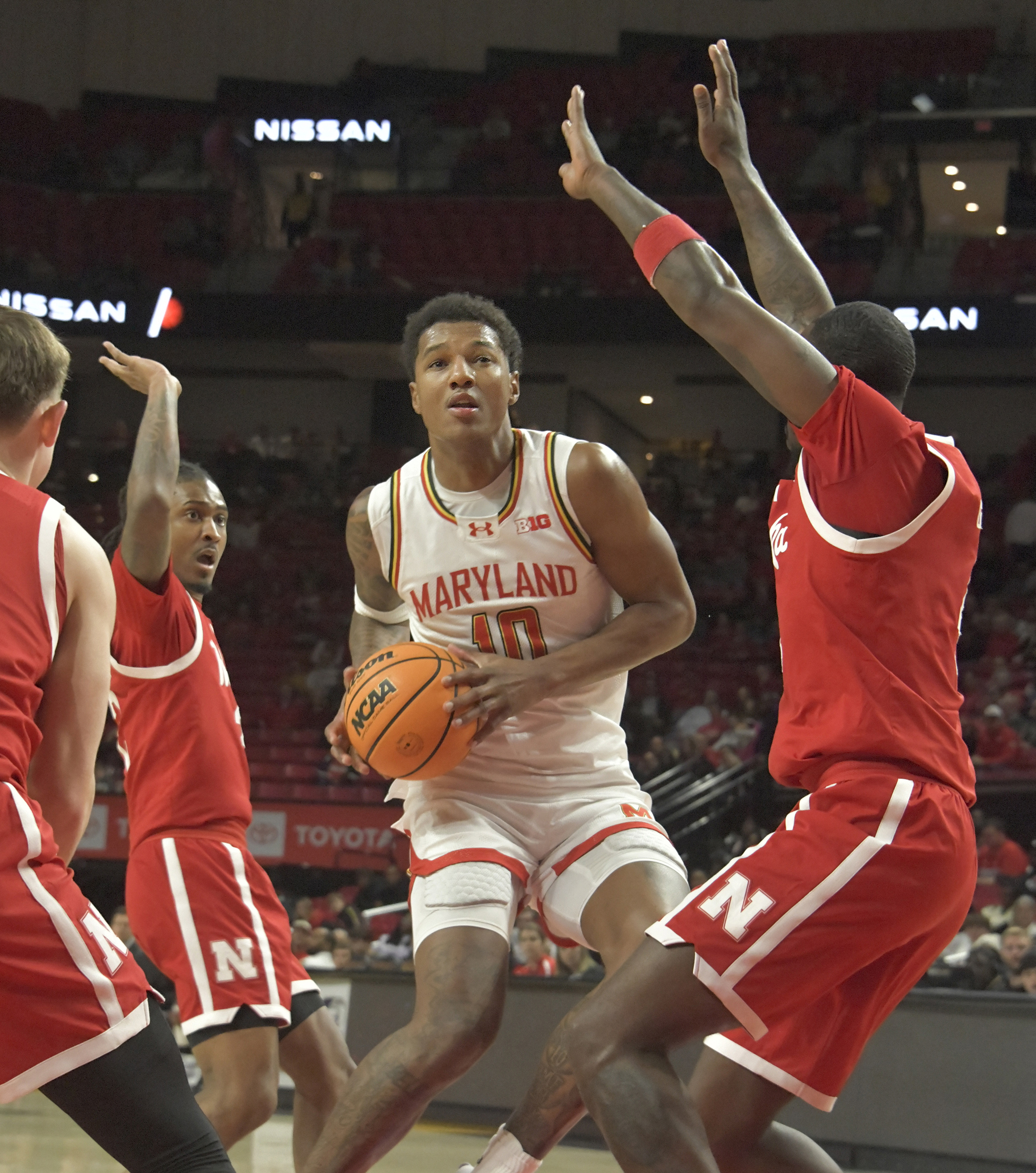 Maryland's Julian Reese #10 looks for an opening under the basket while being surrounded by Nebraska's Ahron Ulis #2, second from left, and Juwan Gary #4, right. The Terps pulled out the win over the Cornhuskers, 69 - 66. (Amy Davis/Staff)