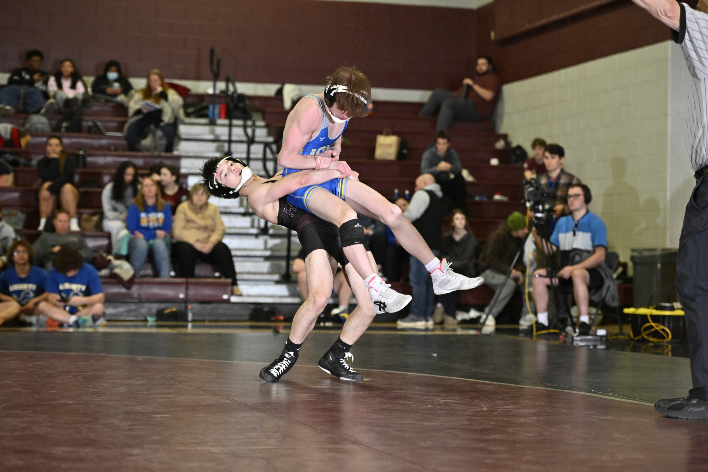 Winters Mill's Lazarus Munson lifts Liberty's Josh Moore during a...