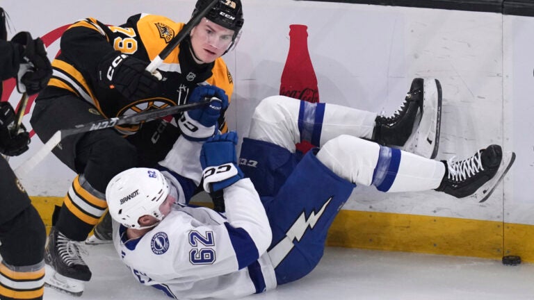 Boston Bruins defenseman Michael Callahan, left, drops Tampa Bay Lightning center Jack Finley to the ice during the first period of an NHL hockey game, Tuesday, Jan. 14, 2025, in Boston.