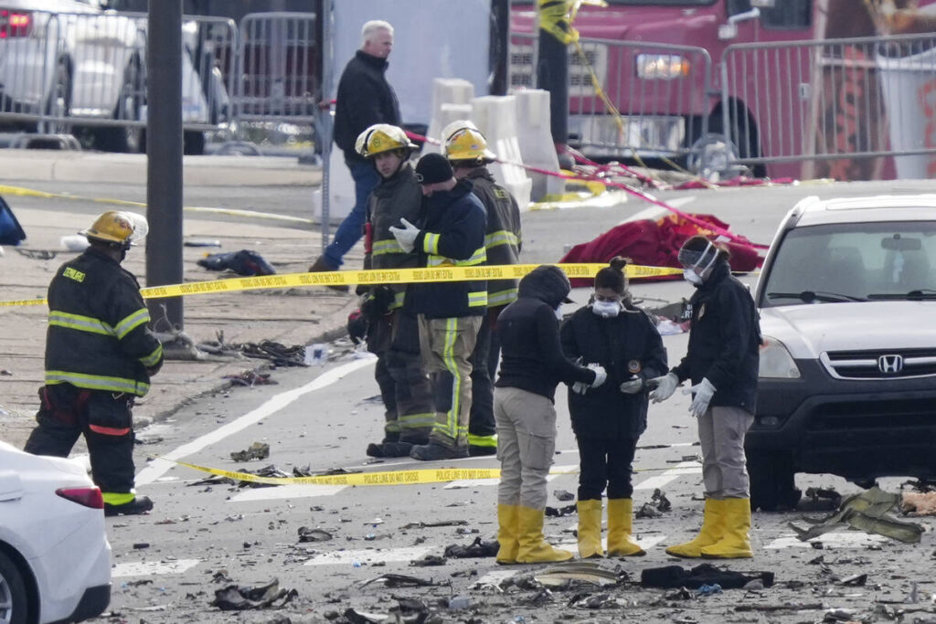 Investigators work the scene after a small plane crashed in Philadelphia, Saturday, Feb. 1, 202 ...