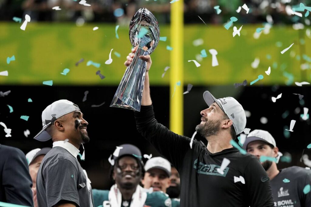 Philadelphia Eagles head coach Nick Sirianni, right, lifts the Vince Lombardi Trophy next to qu ...
