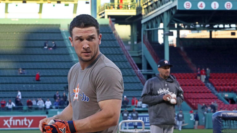 Astros 3B Alex Bregman is pictured during batting practice, in the backrpound at upper left some fans visit the red "Ted Williams" seat in the bleachers, with Willams' retired number 9 visible on the facade at upper right. The Boston Red Sox hosted the Houston Astros in Game Two of their ALCS baseball matchup at Fenway Park.