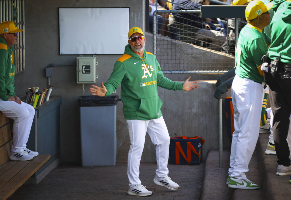 Athletics manager Mark Kotsay talks in the dugout during a Big League Weekend baseball game aga ...