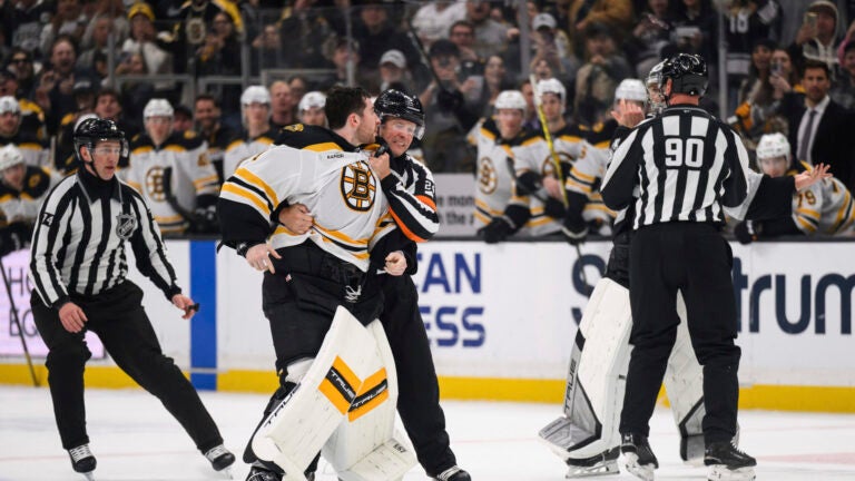 Boston Bruins goaltender Jeremy Swayman, left, is held back from fighting Los Angeles Kings goaltender Darcy Kuemper during the second period of an NHL hockey game Sunday, March 23, 2025, in Los Angeles.