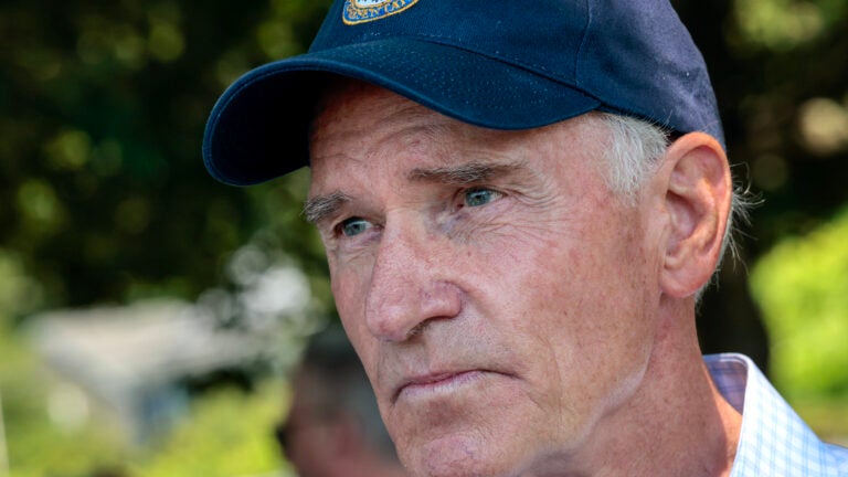 Headshot Congressman Bill Keating, wearing a blue collared shirt and navy baseball cap.