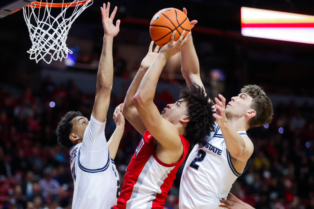 Rebels forward Jalen Hill (1) puts up a shot against Utah State Aggies defense during a Mountai ...