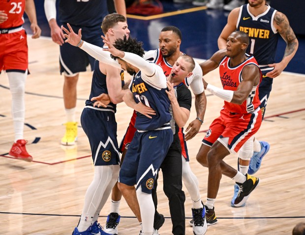 Jamal Murray (27) of the Denver Nuggets is held by...