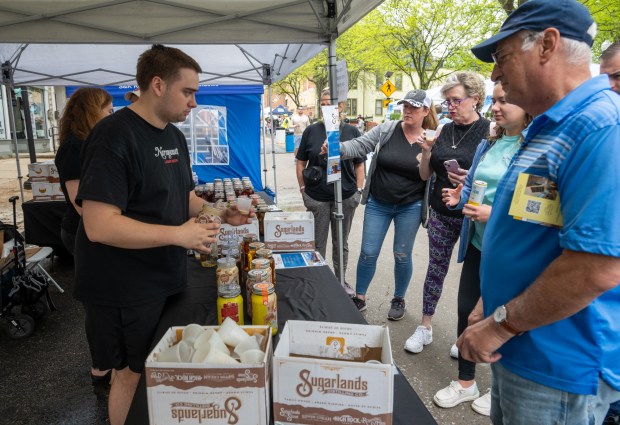 Eric Klein from Mainstreet Liquors in Heampstead gives samples of chocolate coffee flavored Sugarlands Sippin' cream liqueur to guests attending the Westminster Wine Stroll on Main Street. (Karen Jackson/Freelance)