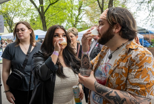 Soni Biedronski and Lane Biedronski sample chocolate coffee flavored Sugarlands Sippin' cream liqueur offered at Mainstreet Liquors of Hampstead during the Westminster Wine Stroll on Main Street. (Karen Jackson/Freelance)
