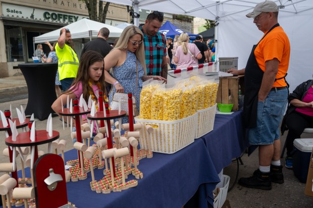 Reighlynn Bosley, 8, Kristina Bosley and Steven Bosley shop for gourmet popcorn at The Caramel Kettle with owner Tom Dixon at the Westminster Wine Stroll on Main Street. (Karen Jackson/Freelance)