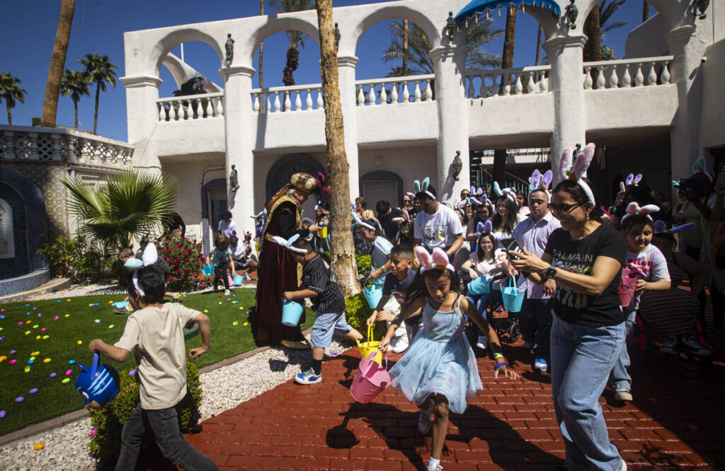 Children race to hunt eggs during an Easter celebration for members of the Down Syndrome Organi ...