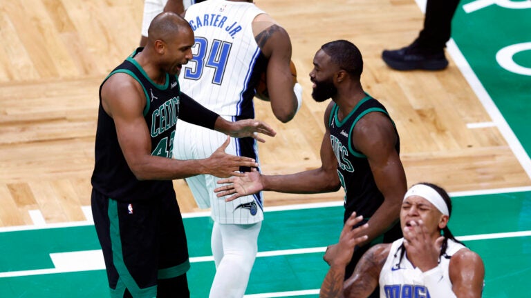 Boston Celtics center Al Horford (42) and Boston Celtics guard Jaylen Brown (7) celebrate as Orlando Magic forward Paolo Banchero (5) reacts to fouling Brown during the third quarter in game five of the NBA Eastern Conference playoffs against the Orlando Magic at TD Garden.