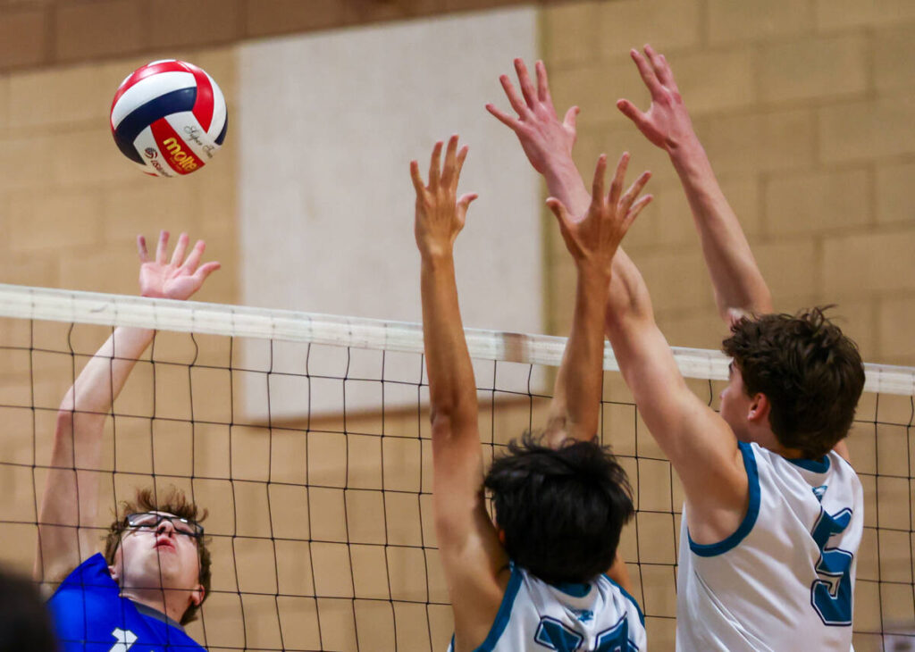 Basic outside hitter Ethan Hunt (15) takes a swing against Somerset Sky Pointe blockers Antonio ...