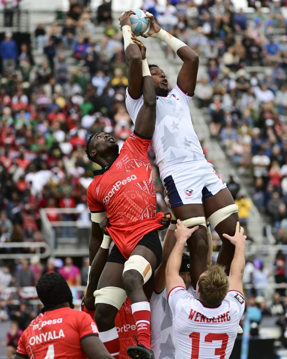 Aaron Cummings of the U.S., top, competes for a line-out against George Ooro Angeyoof of Kenya.