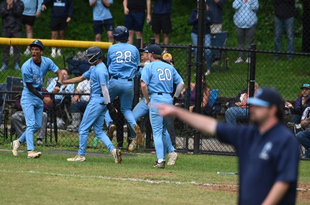 Chesapeake players celebrate scoring a pair of runs against Northeast...