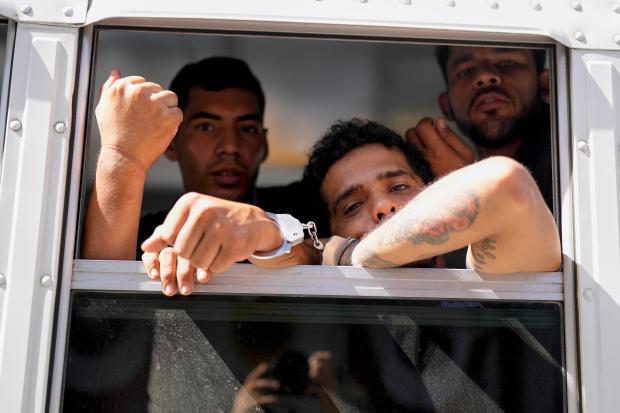 Colombian migrants look out from a Panamanian immigration bus transporting...