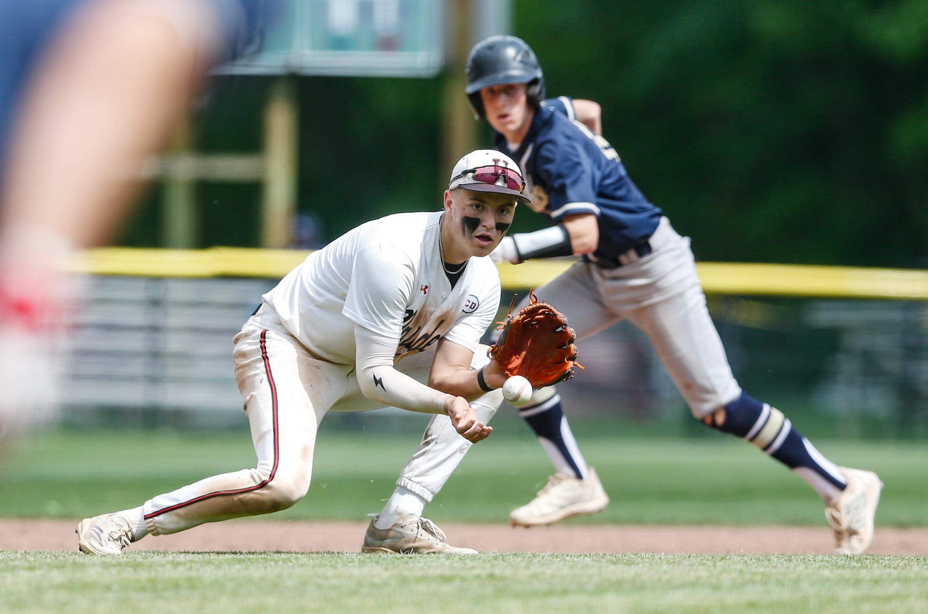 William Kraemer (2) of Hun fields a ground ball with Evan Treese (10) of Peddie running behind the play during the Prep A semifinal baseball game between Hun and Peddie at The Hun School of Princeton in Princeton, NJ on 5/18/25.