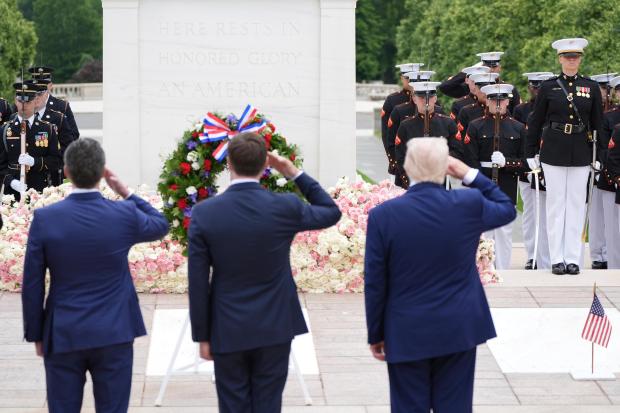 President Donald Trump, standing right, salutes at the Tomb of...