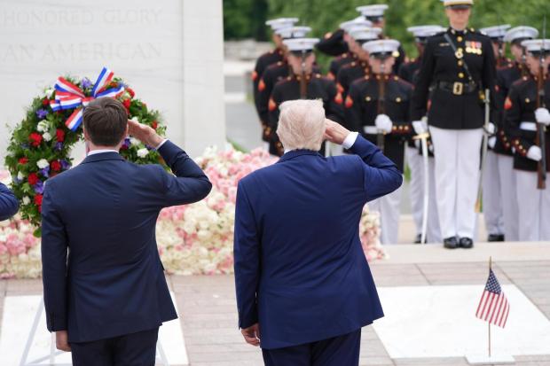 President Donald Trump, right, salutes at the Tomb of the...