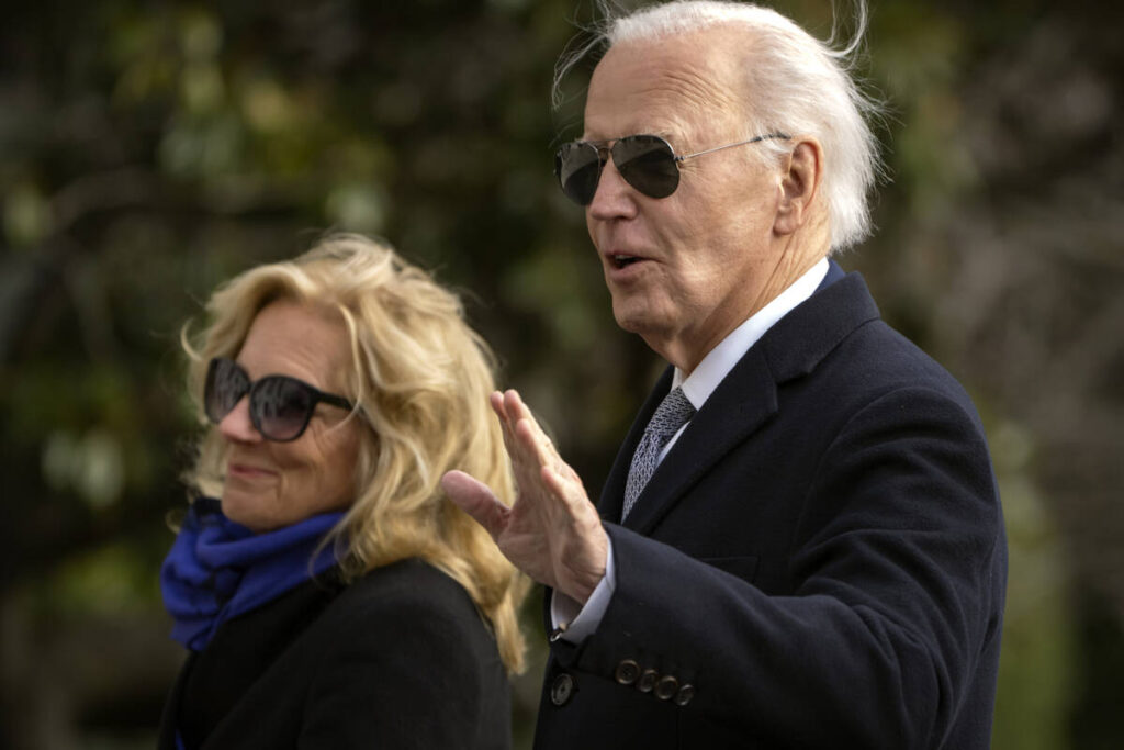 President Joe Biden gestures as he and first lady Jill Biden walk across the South Lawn of the ...