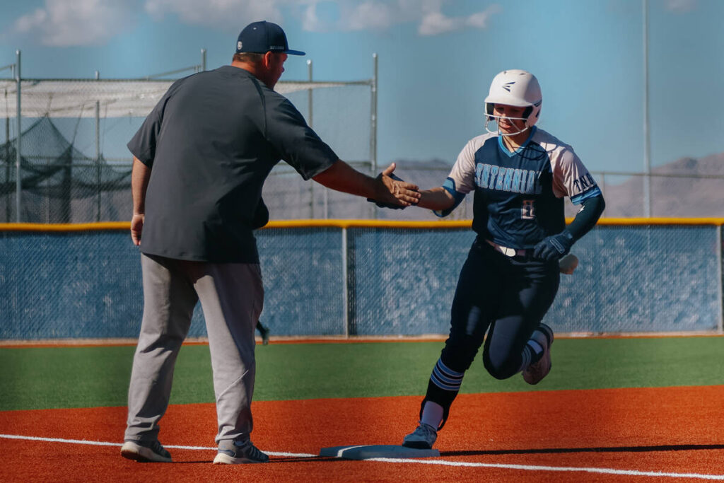 Centennial’s Sloane Merrell (8) high fives her coach as she rounds third base after hitt ...