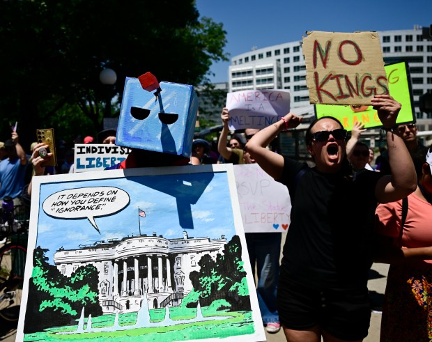 "No Kings" protesters rally along Lincoln Street near Colfax Avenue...