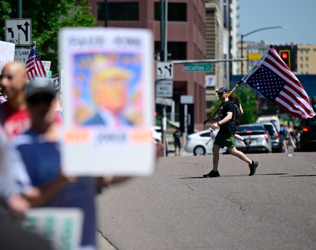 A protester walk across Lincoln Street across from the Capitol...