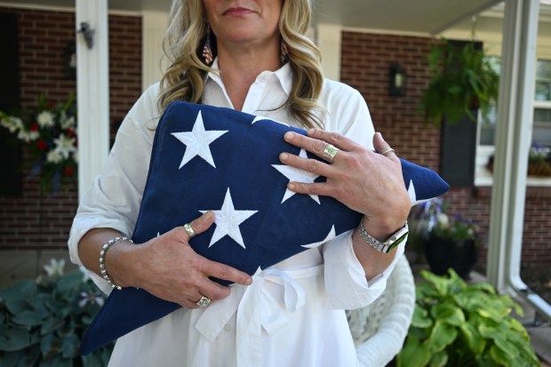 Heather Holmes holds the flag presented to her during the funeral for World War II glider pilot Raymond Farris Chambers, outside her home in Denver on June 18, 2025. (Photo by RJ Sangosti/The Denver Post)