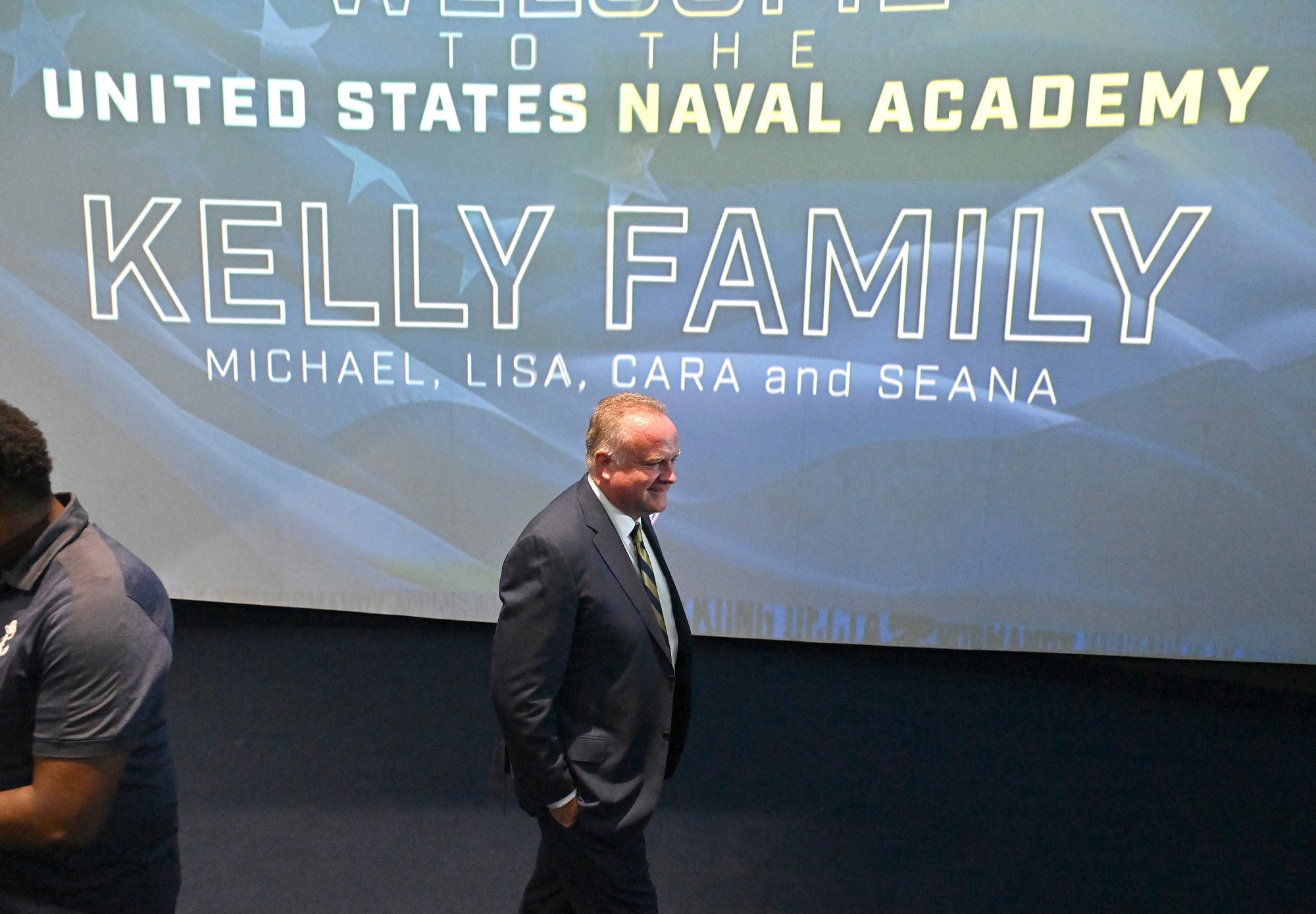 New Athletic Director Michael Kelly walks by the welcoming screen. Outgoing Navy Athletic Director Chet Gladchuk said his goodbyes to staff today and introduced new Navy athletic director Michael Kelly during an event at academy. (Paul W. Gillespie/Staff)
