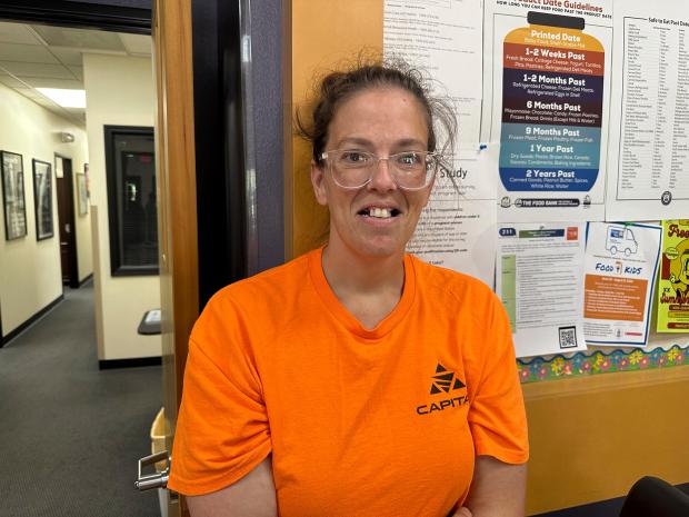 Theresa Gibbs stands near a poster showing typical food expiration...