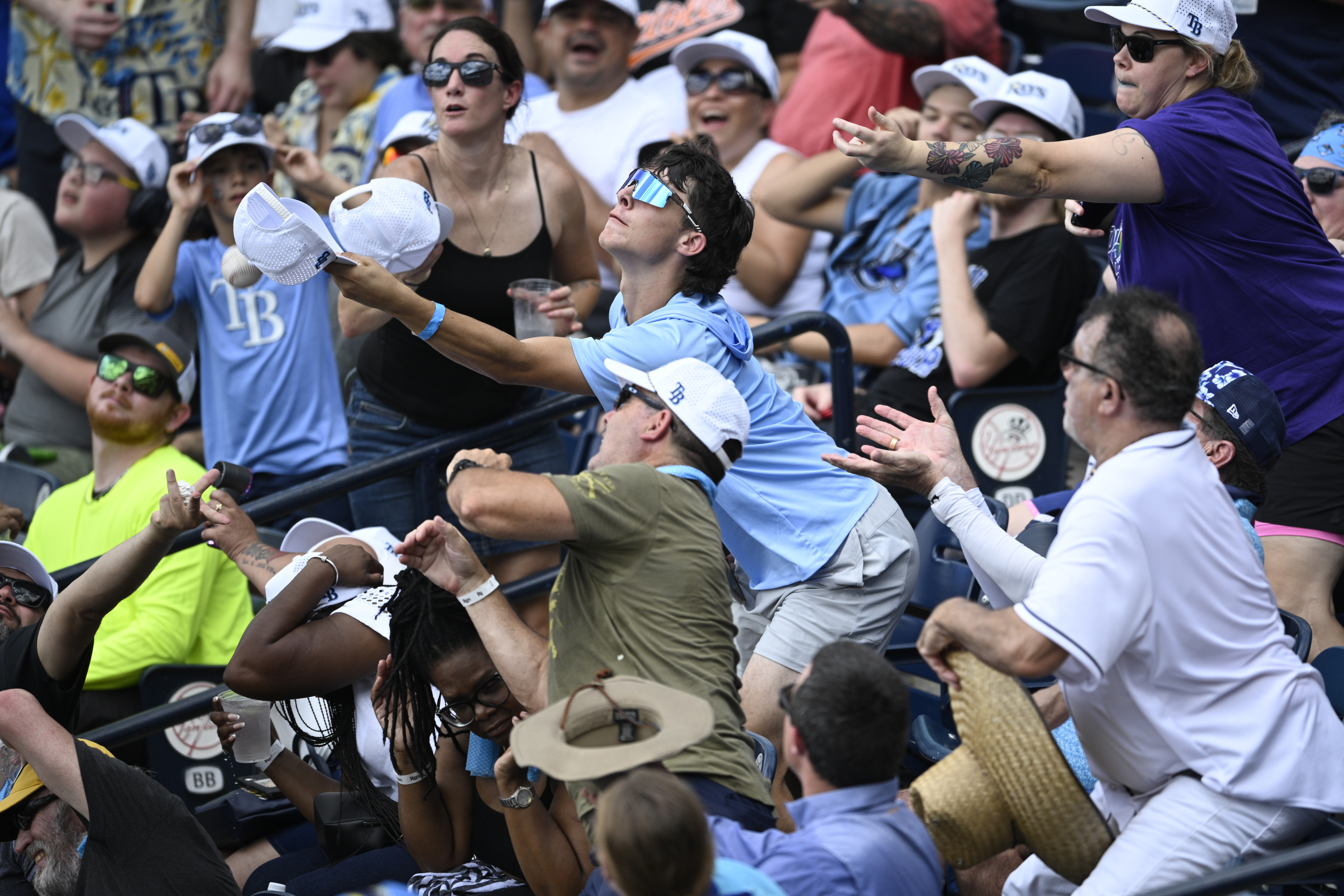 Spectators reach for a foul ball hit by Baltimore Orioles'...