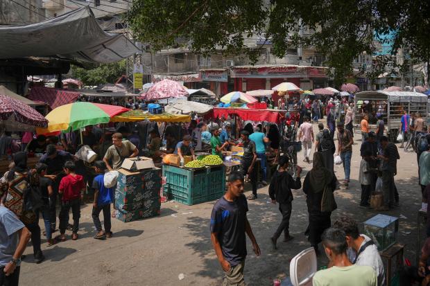Palestinians shop at a makeshift market in Deir al-Balah, central...