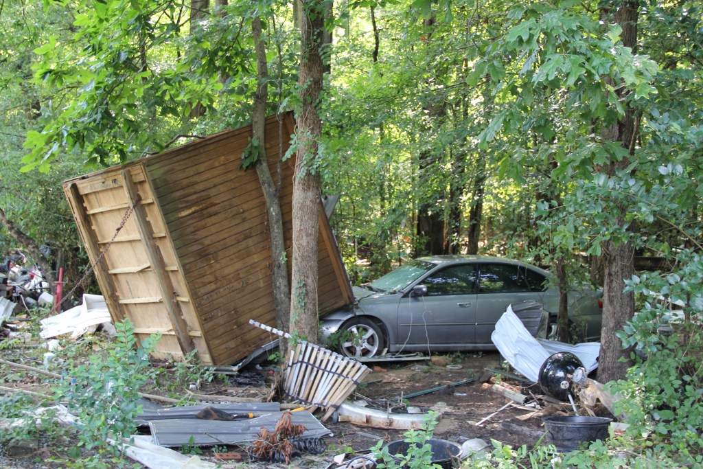 Horton’s shed sits crashed against a neighbor’s car on July 15. During Tropical Storm Chantal, the shed floated 200 feet before coming to rest here.