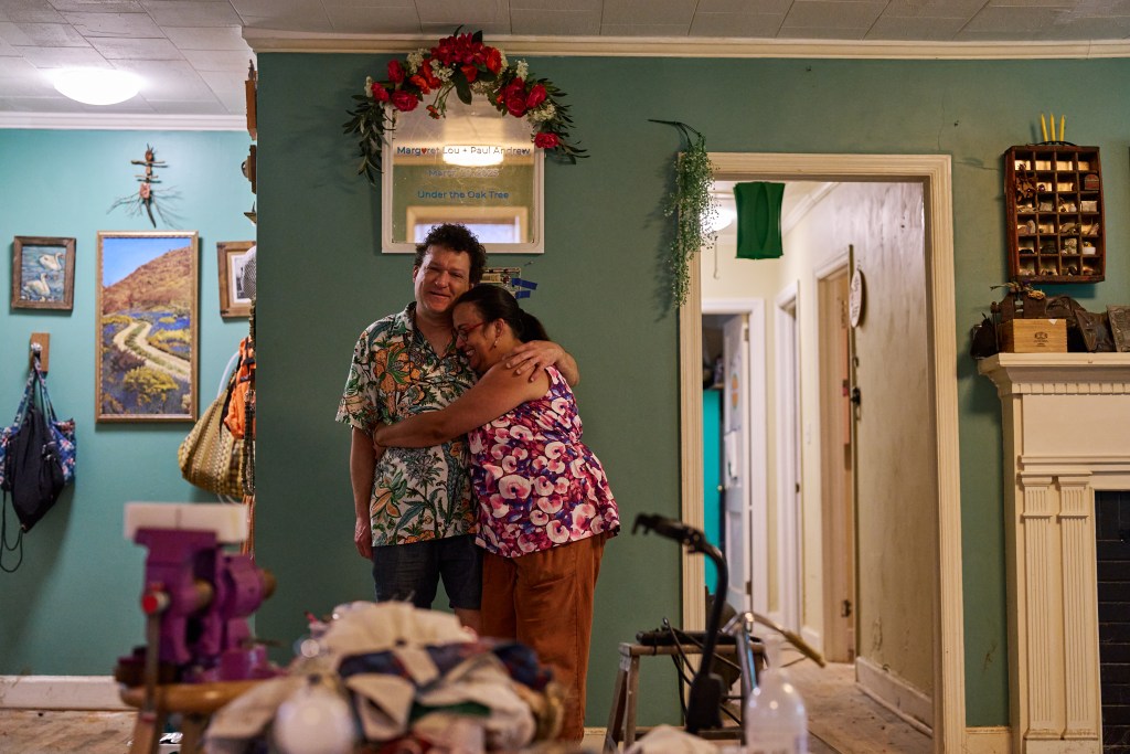 Paul Greganti and Lou Horton pose for a portrait in their home after it was flooded during Tropical Storm Chantal in Chapel Hill, NC.