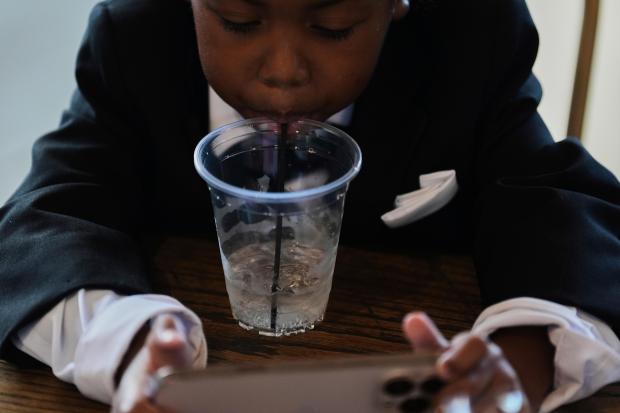 Legend McNeary, 4, takes a sip of water while sitting...