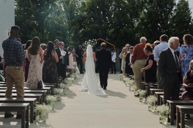 Kayla McDonald walks down the aisle with her father, Chris,...