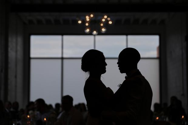 Newlyweds Kayla McDonald, left, and Tyler Jones, right, dance during...