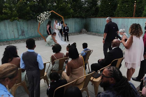 Newlyweds Kayla McDonald and Tyler Jones pose for family photos during their wedding Saturday, Aug. 23, 2025, in Newtown, Ohio. (AP Photo/Joshua A. Bickel)