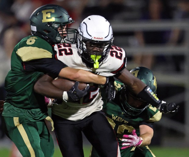 Aurora Christian's Jalen Callaway (22) slips past St. Edward defenders Brandon Wilmot (6) and Anthony Leadley (26) in the second quarter during a Chicagoland Christian Conference game Friday, Sept. 12, 2025 in Elgin. (H. Rick Bamman / The Beacon-News)