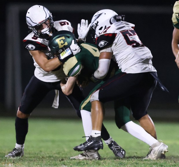 Aurora Christian's Dominic Klimpke (9) and Justin Douglas (57) wrap up St. Edward's Jake Linkowski (4) in the first quarter during a Chicagoland Christian Conference game Friday, Sept. 12, 2025 in Elgin. (H. Rick Bamman / The Beacon-News)