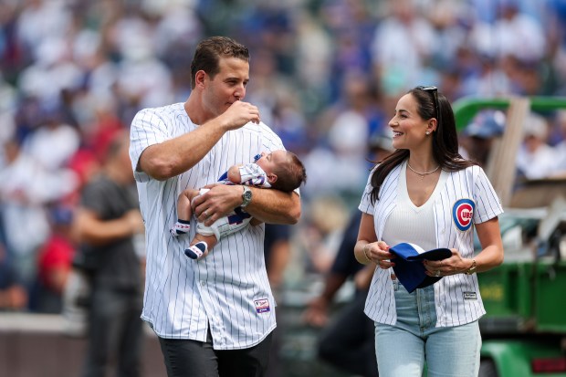 Former Cubs first baseman Anthony Rizzo and his wife Emily walk on the field with their child before the Cubs play the Tampa Bay Rays at Wrigley Field after the Cubs announced he would retire and become an ambassador for the team he helped lead to a World Series in 2016 Saturday Sept. 13, 2025, in Chicago. (Armando L. Sanchez/Chicago Tribune)