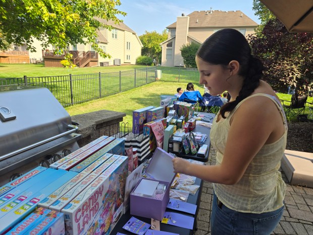 Elgin resident Abby Richlen, a pediatric cancer survivor, selects a prize after winning a bingo game at Anne Won's "gold party" in South Elgin, so-called because gold is the color of Pediatric Cancer Awareness Month. (Gloria Casas/The Courier-News)