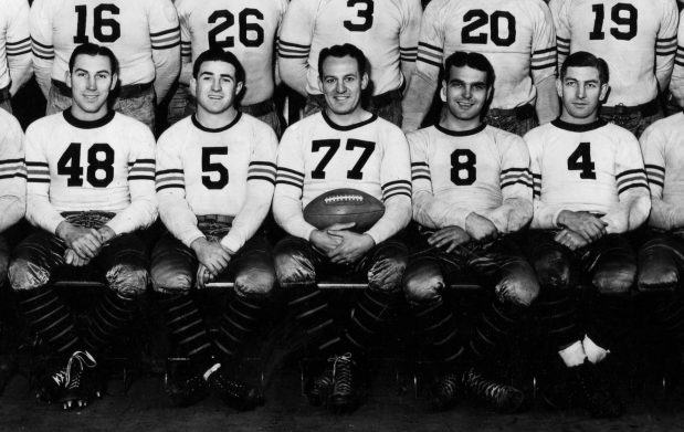 Red Grange (77), center, poses with Beattie Feathers, from left, George Corbett, Grange, Carl Brumbaugh and Keith Molesworth in 1934. The cream-colored road jersey worn by Grange circa 1933-1934 will be auctioned by Christie's on Oct. 22, 2025. (George Burke)
