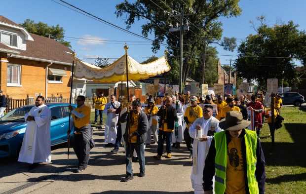 Members of the procession march while praying and worshiping during...