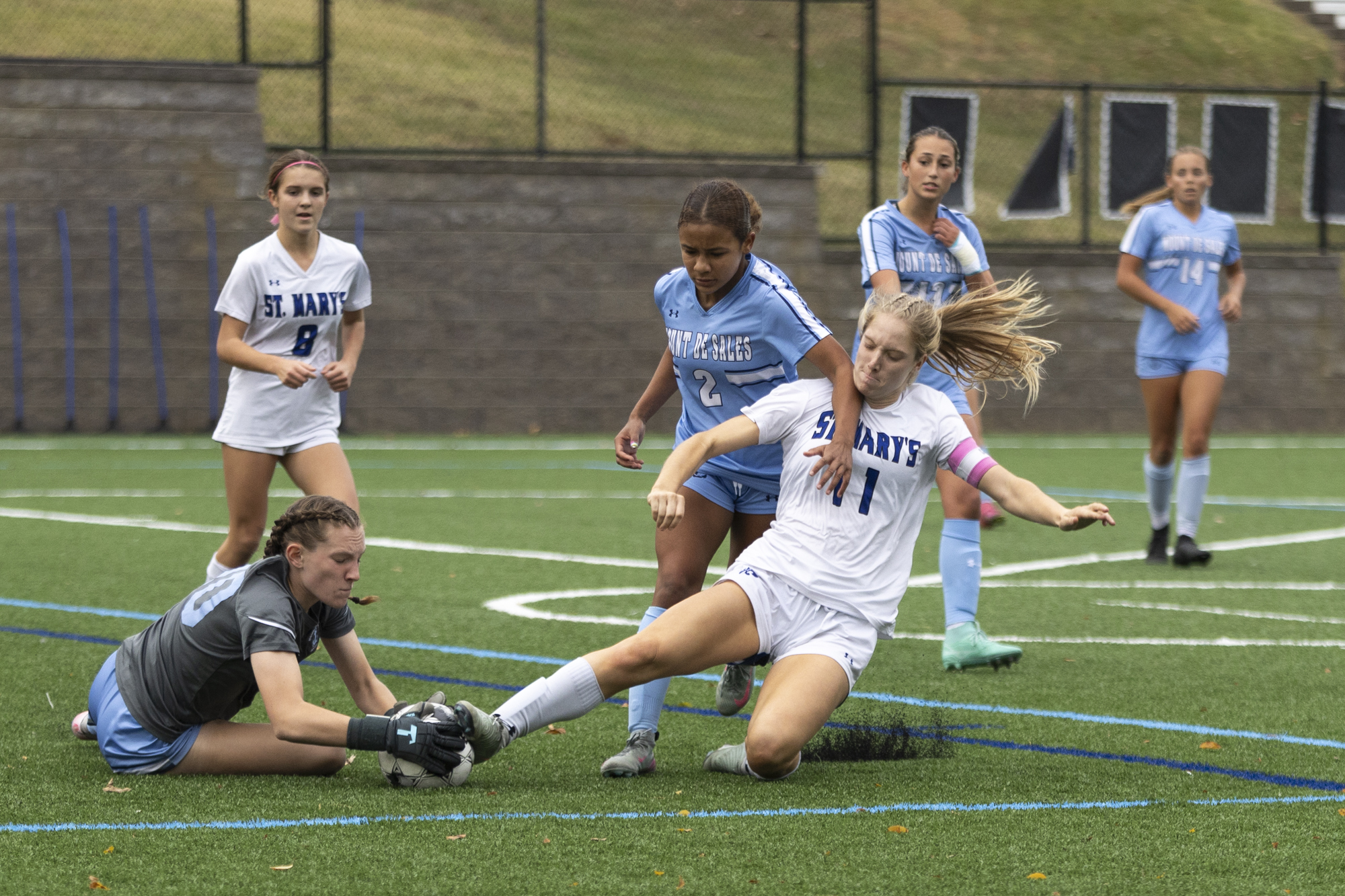 Saint Mary’s Elizabeth Schummer slide tackles the ball as Mount...
