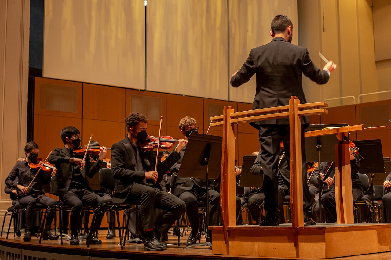 Young masked musicians on stage.