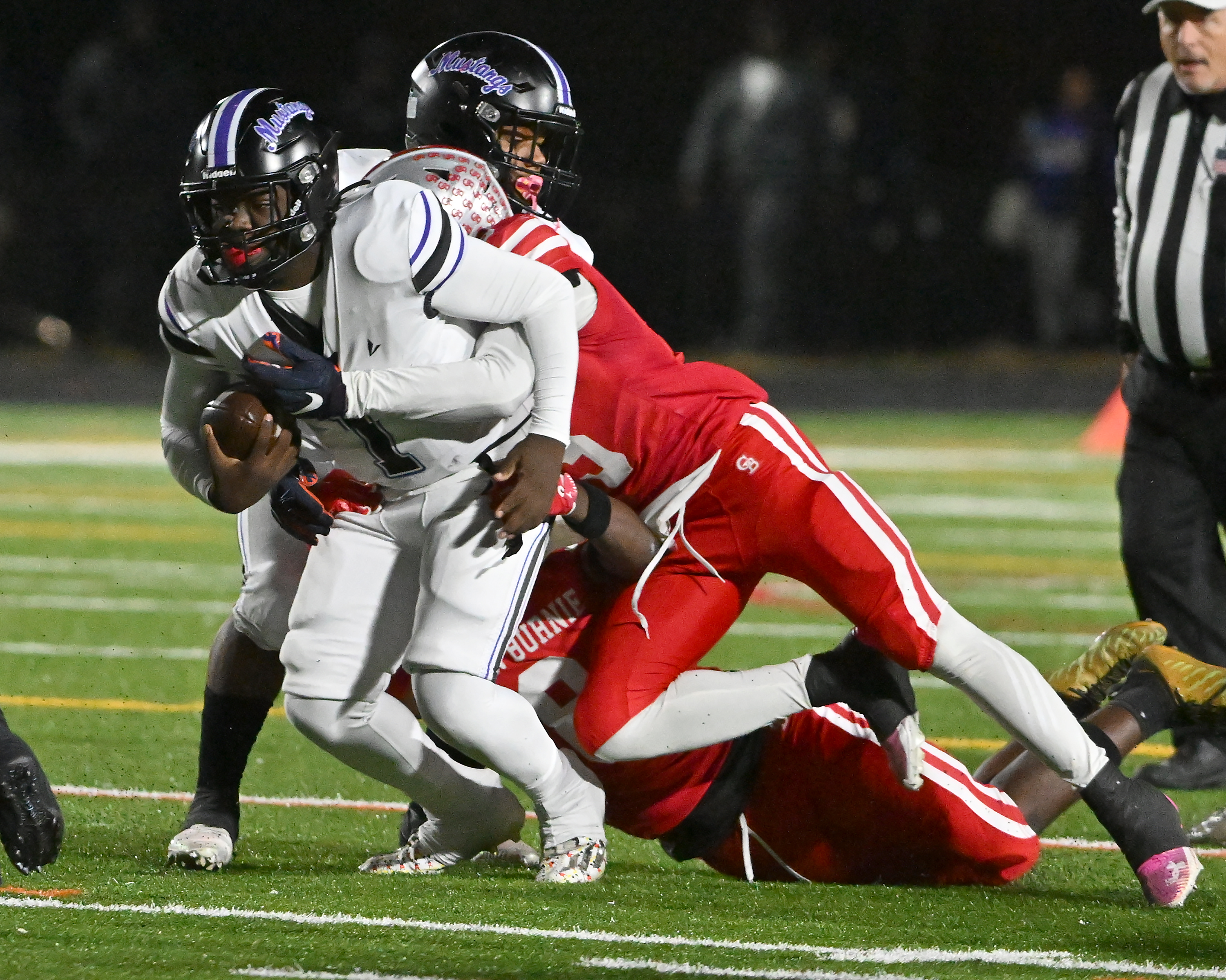 Nov. 14, 2025: Glen Burnie's Kendall Taylor ​and Kendrick Taylor ​sack Meade quarterback K'dyn Rogers in the second quarter. The Glen Burnie Gophers defeat the visiting Meade Mustangs, 41-35, in a MPSSAA Class 4A East Region second round playoff football game. (Paul W. Gillespie/Staff)