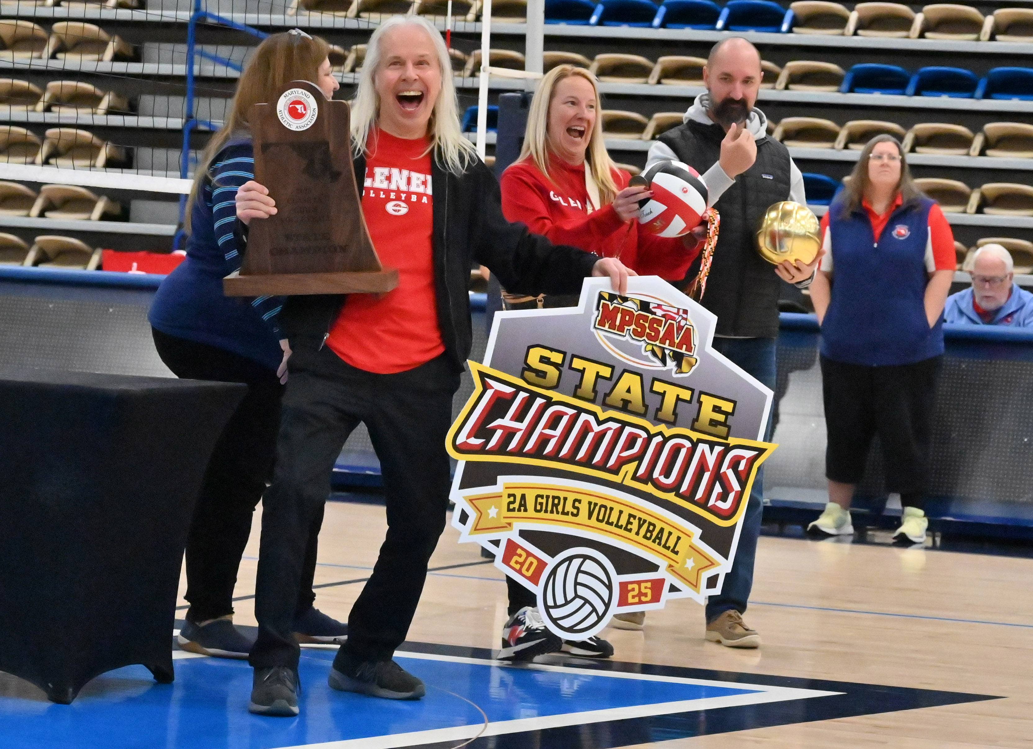 Glenelg coach Nick Sharp accepts the championship trophy following the team's win over Williamsport during the Class 2A volleyball state championship at Harford Community College on Saturday. (Brian Krista/Staff)