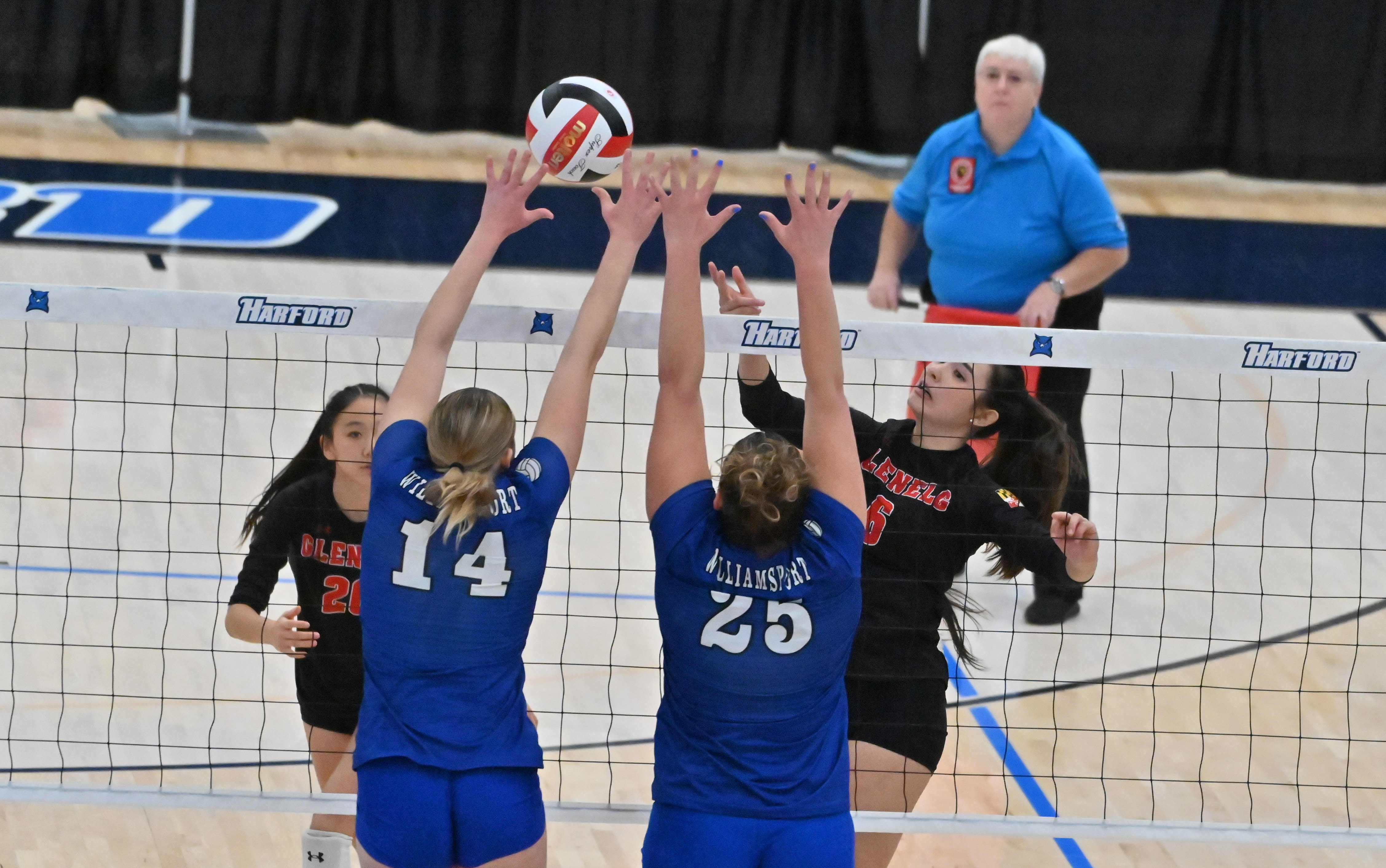 Glenelg's Lainey White hits the ball over Williamsport blockers Elliana Schwartz, left, and Hannah Small during the Class 2A volleyball state championship at Harford Community College on Saturday. (Brian Krista/Staff)