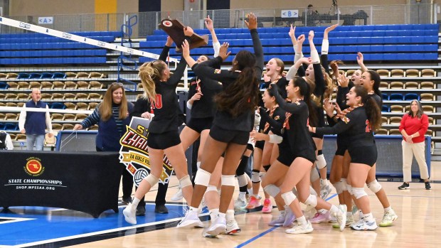 Glenelg's volleyball team celebrates with their trophy following their win over Williamsport during the Class 2A volleyball state championship at Harford Community College on Saturday. (Brian Krista/Staff)